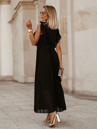 a woman wearing a black dress and heels