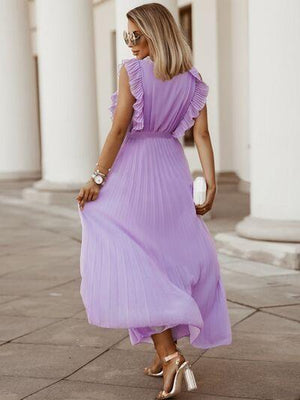 a woman in a purple dress is walking down the street