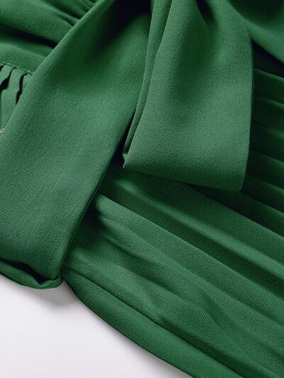 a close up of a green dress on a white surface