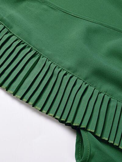 a close up of a green skirt on a white surface