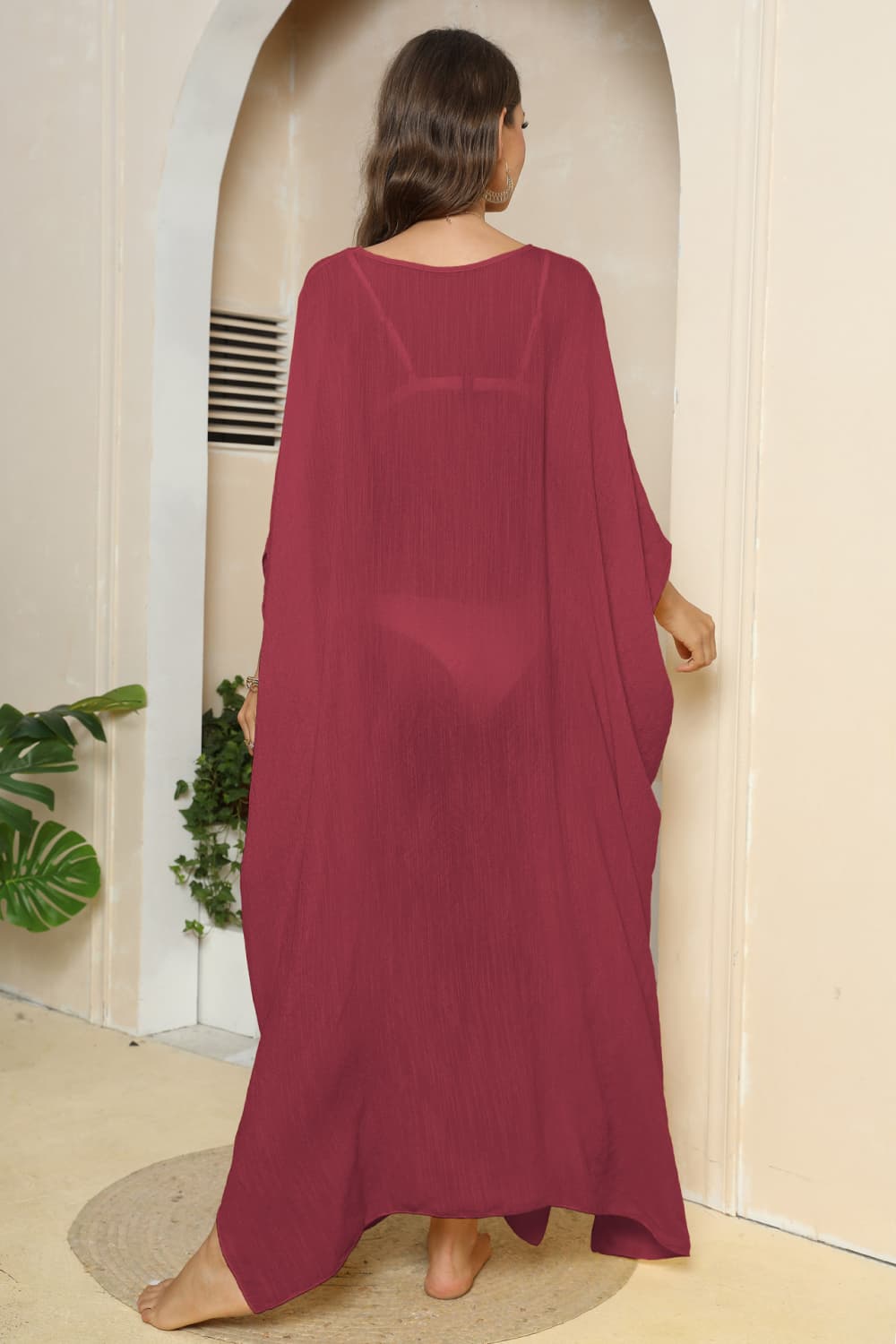 a woman in a red dress standing in front of a doorway