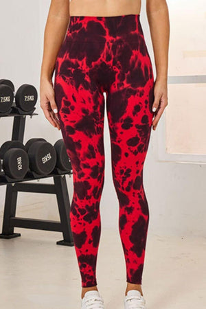 a woman in red and black leggings stands in front of a rack of