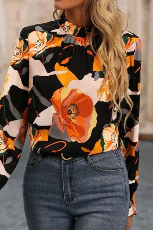 a woman wearing a floral blouse and jeans