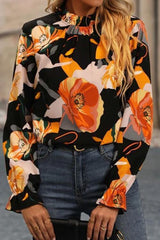 a woman wearing a floral blouse and jeans