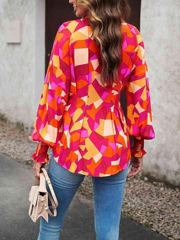 a woman in a colorful top is walking down the street