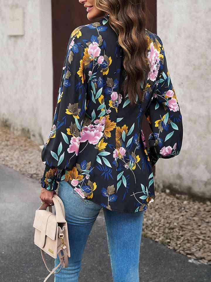 a woman wearing a floral blouse and jeans