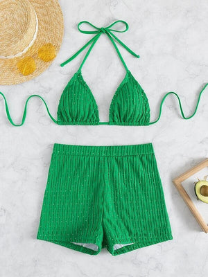 a green bikini top and matching shorts with a straw hat