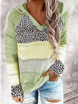 a woman wearing a green sweater and ripped jeans