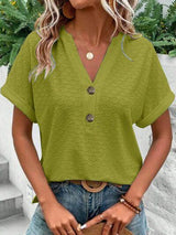 a woman wearing a green top and jeans