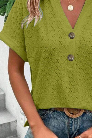 a woman wearing a green shirt and jeans