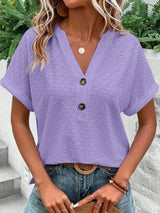 a woman wearing a purple top and jeans