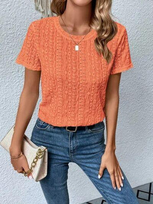 a woman wearing an orange top and jeans