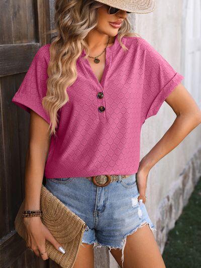 a woman wearing a pink shirt and denim shorts