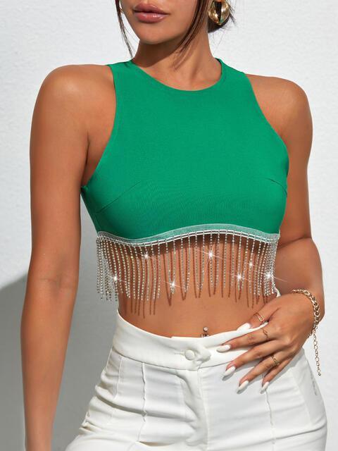 a woman wearing a green crop top and white pants