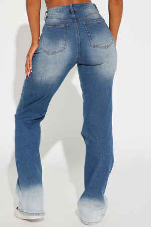 a woman in high rise jeans with her back to the camera