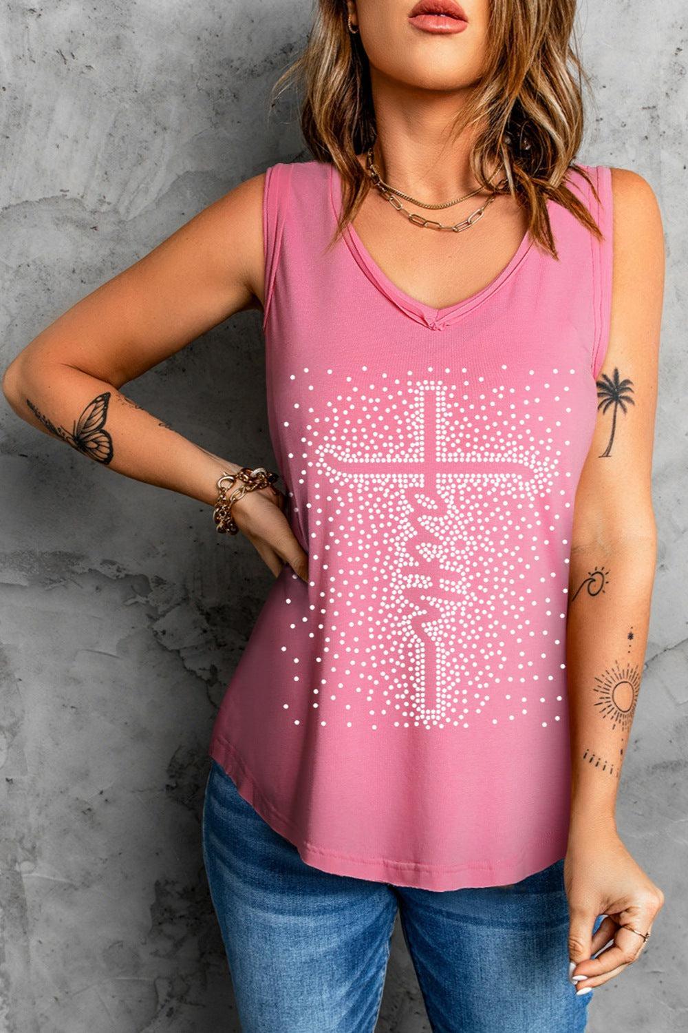 a woman wearing a pink tank top with a cross on it
