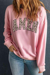 a woman wearing a pink sweatshirt with leopard print