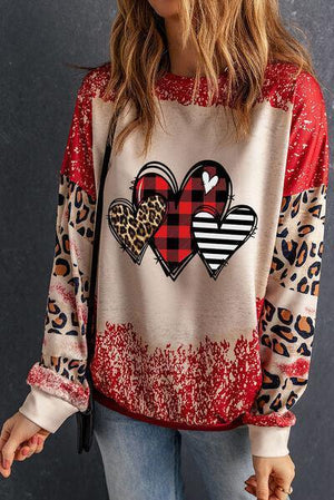 a woman wearing a red and white sweater with hearts on it