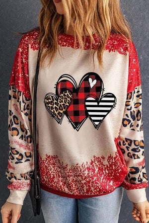 a woman wearing a leopard print heart sweatshirt