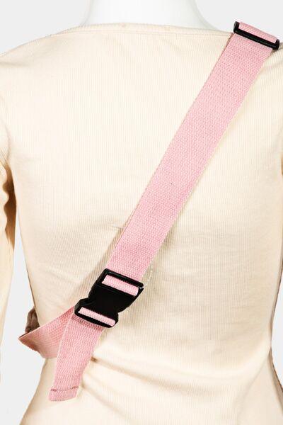 a woman wearing a pink and black shoulder strap