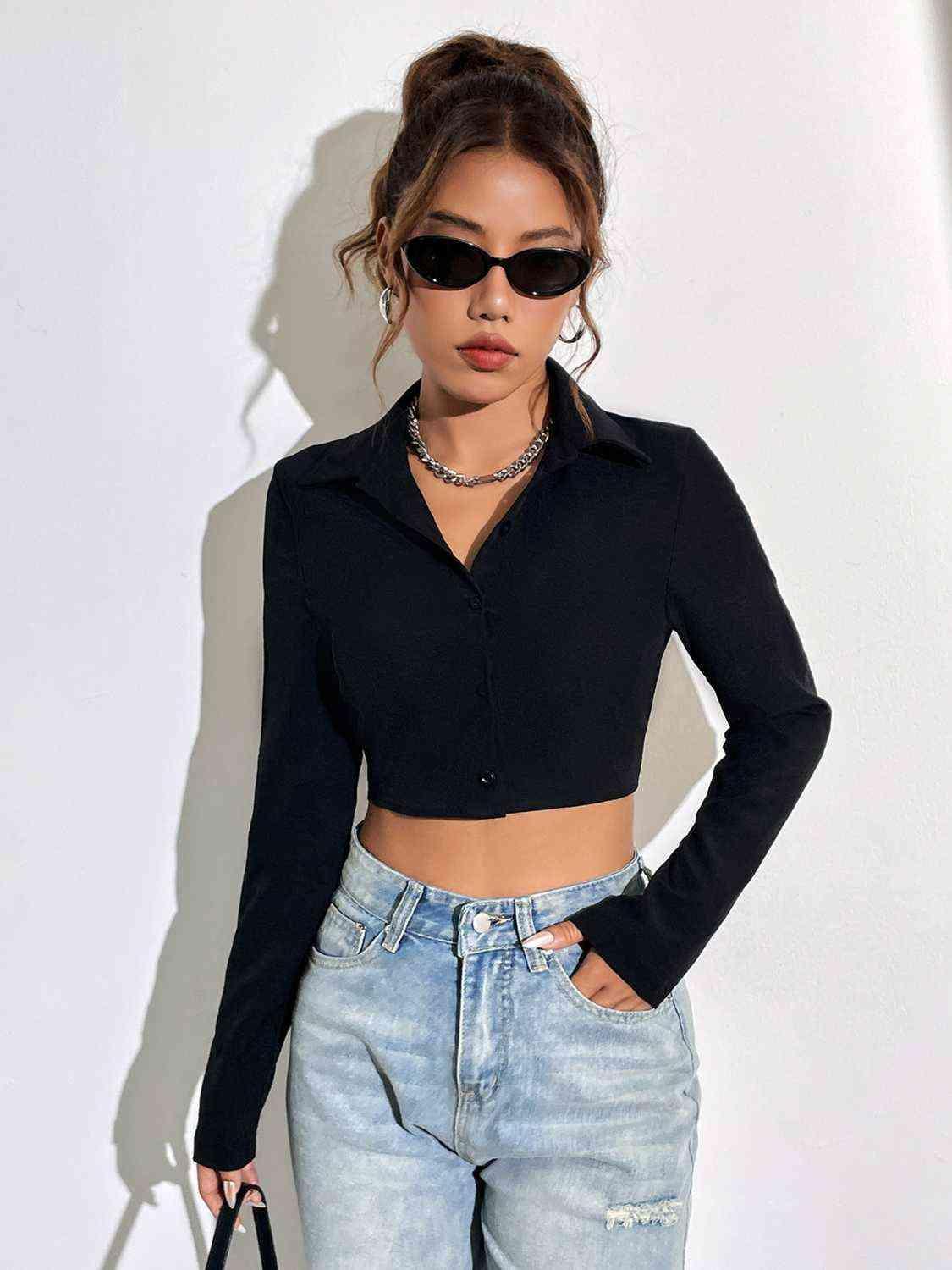 a woman wearing a black crop top and ripped jeans