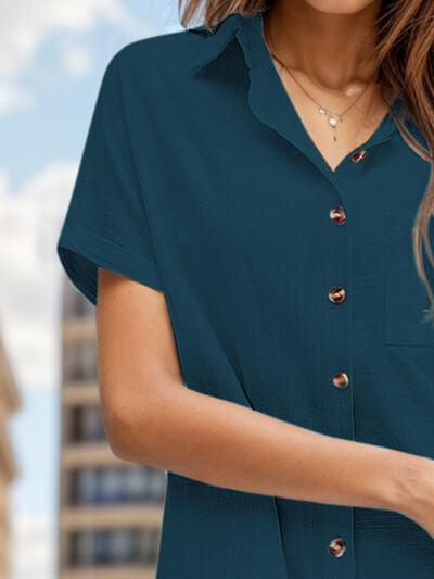 a woman in a blue shirt is holding a cell phone