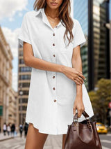 a woman in a white shirt dress holding a brown purse