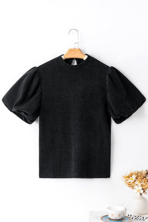 a black t - shirt hanging on a white wall