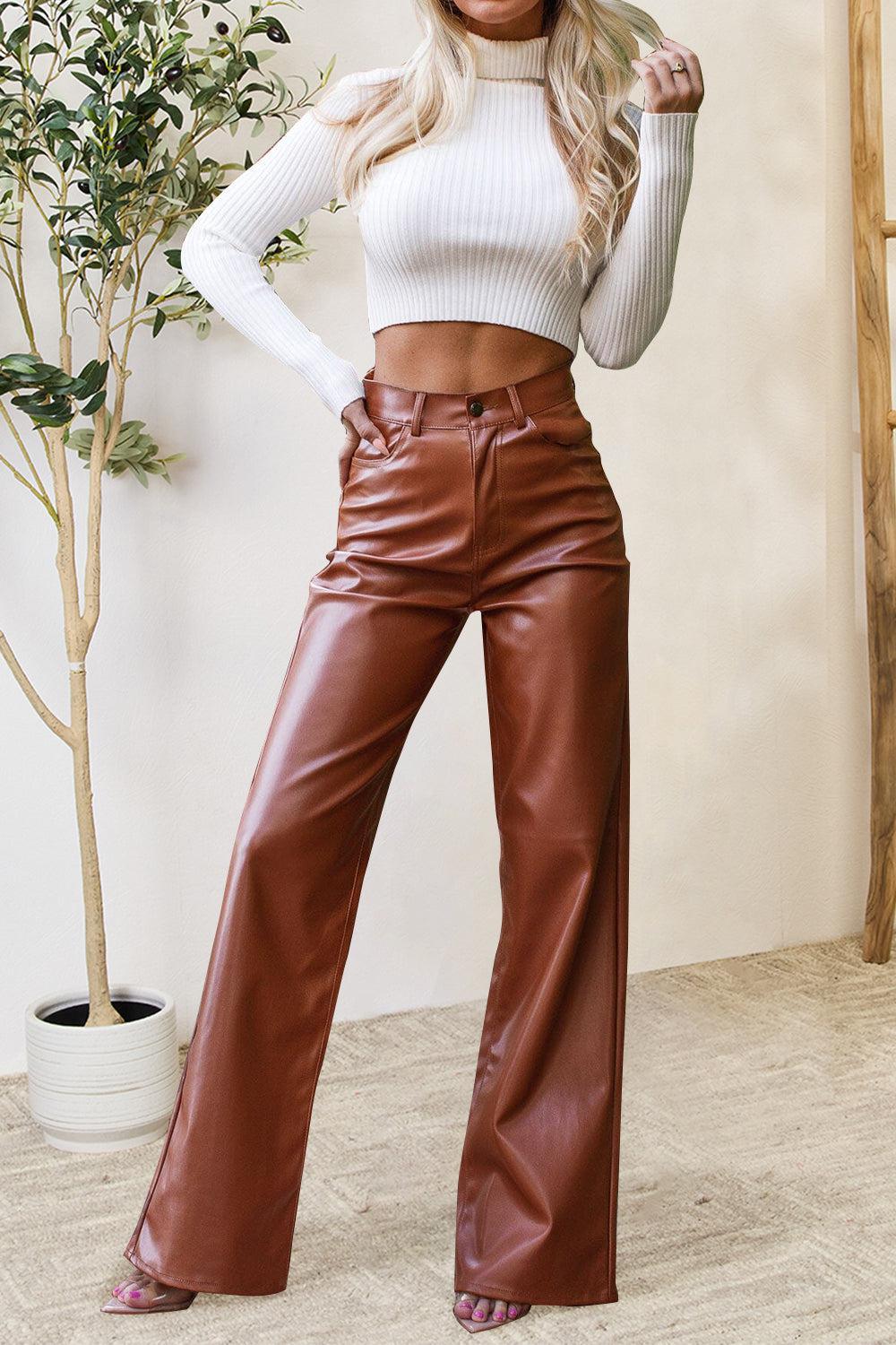 a woman in a white top and brown leather pants