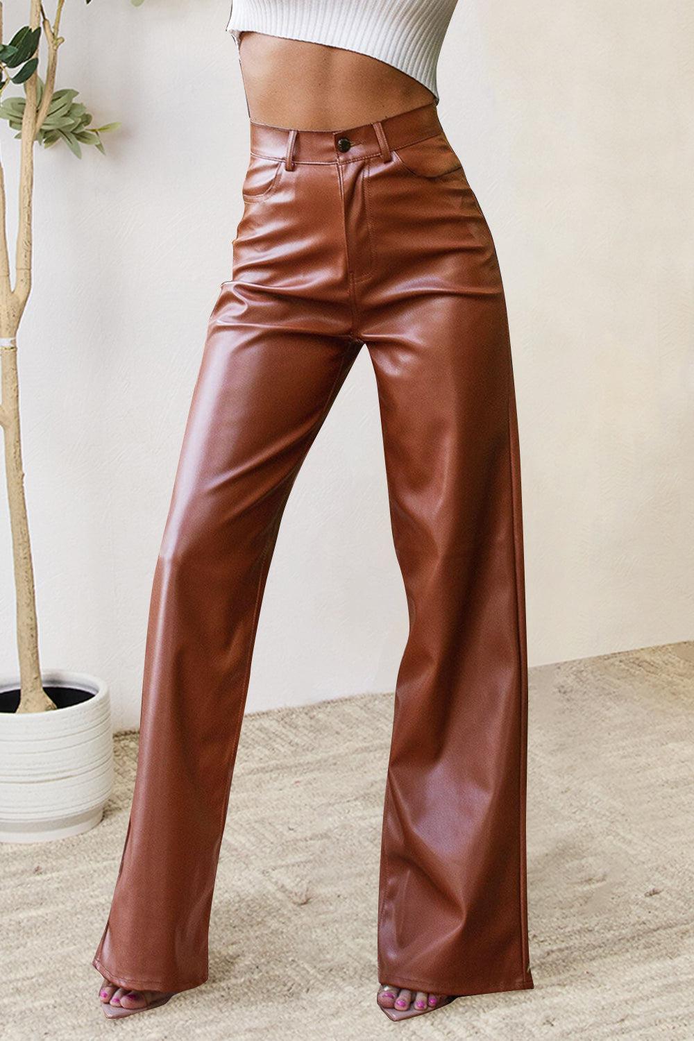 a woman in a white top and brown leather pants