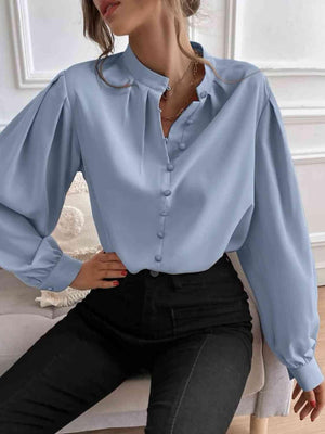 a woman sitting on a couch wearing a blue blouse