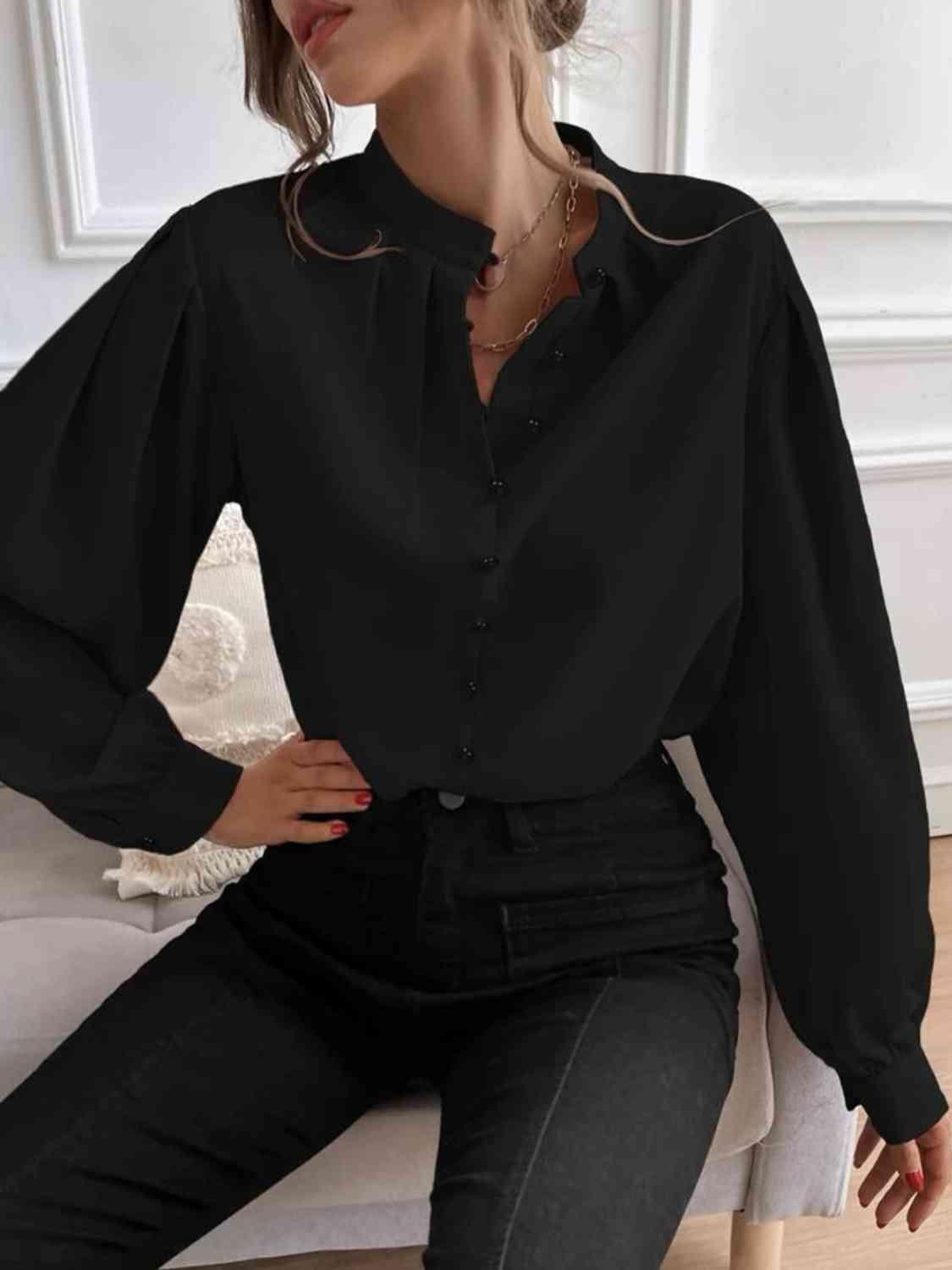 a woman sitting on a couch wearing a black shirt