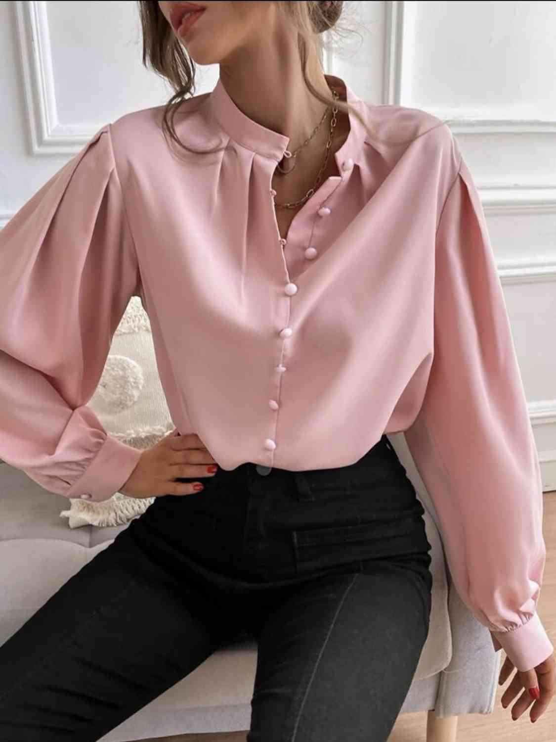 a woman sitting on a couch wearing a pink shirt