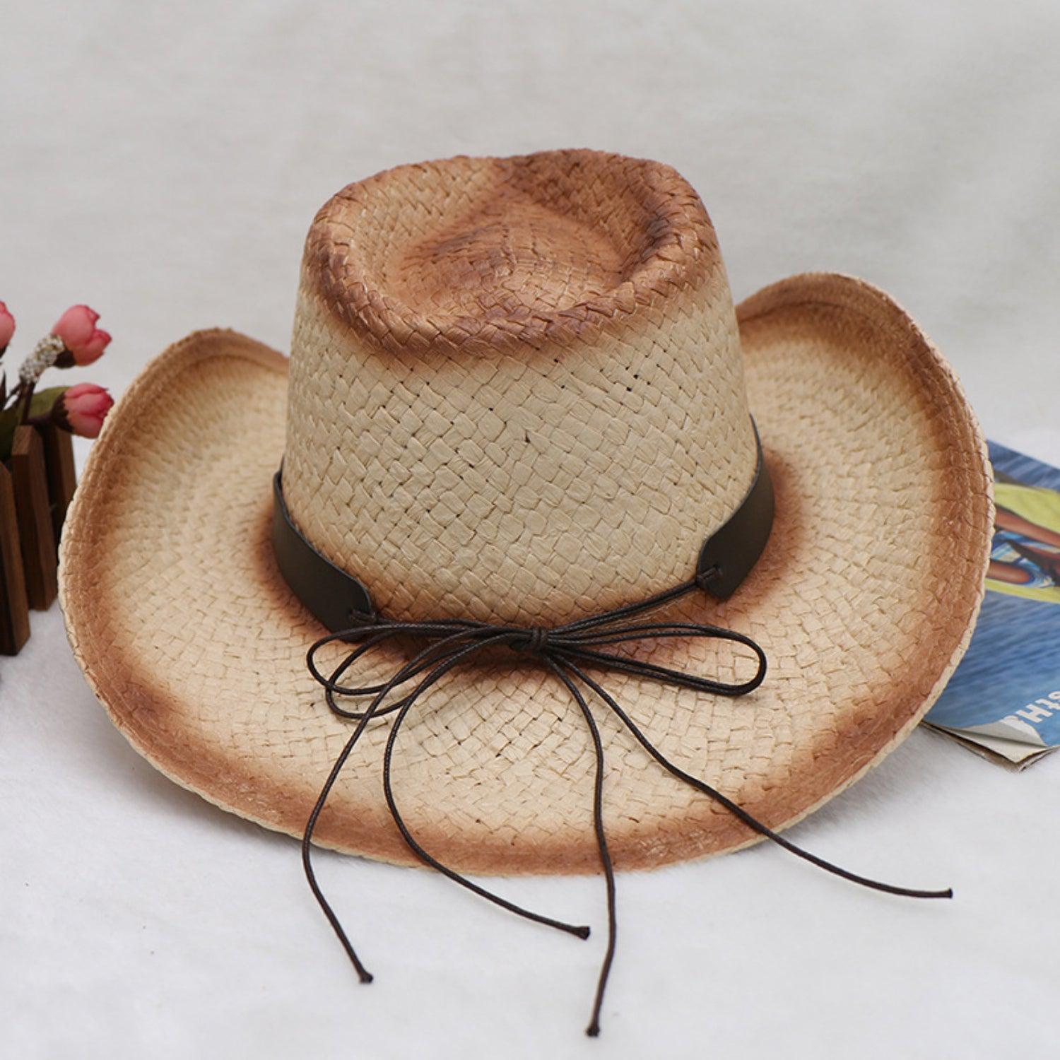 a straw cowboy hat with a brown ribbon around the brim