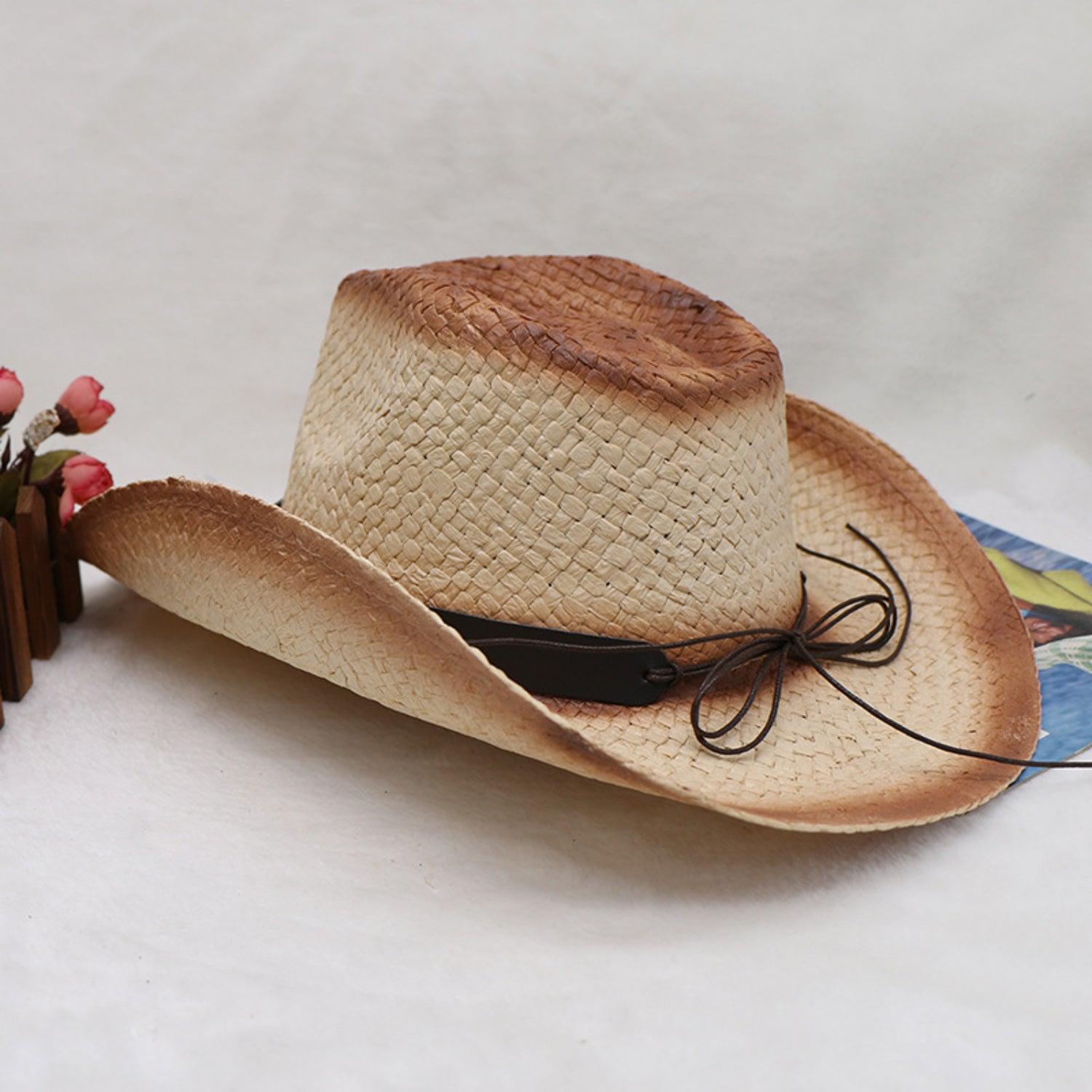 a straw hat with a black ribbon on a white background