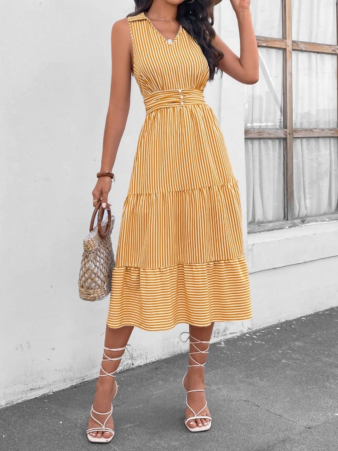 a woman in a yellow striped dress holding a purse