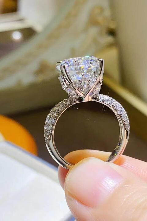 a person holding a diamond ring in their hand