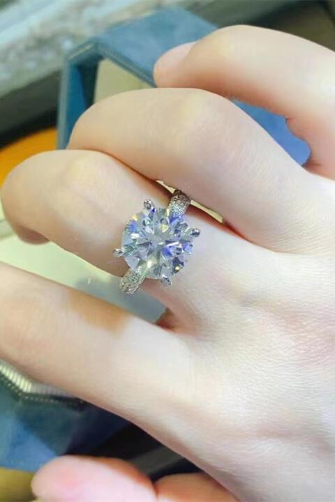 a close up of a person's hand holding a ring