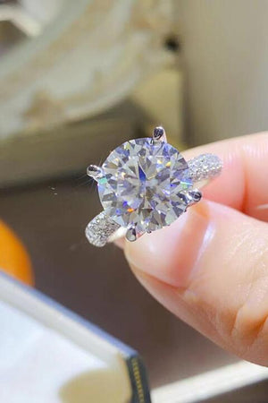 a person holding a diamond ring in their hand