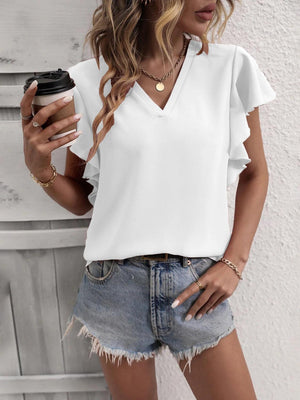 a woman wearing a white top and denim shorts