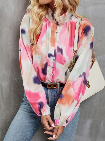 a woman wearing a tie dye blouse and jeans