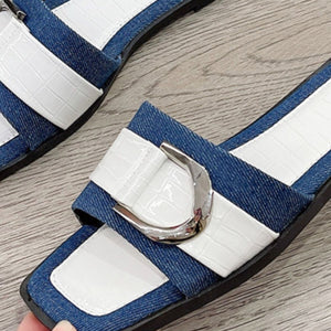 a pair of blue and white shoes with a metal buckle