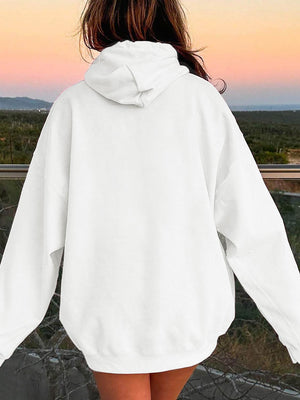 a woman in a white hoodie looking at the sunset