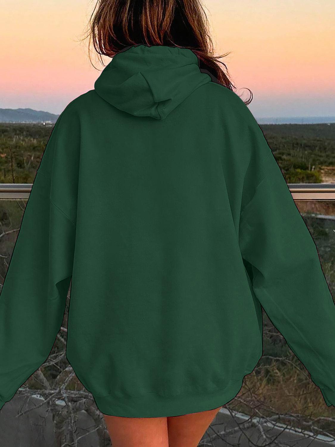 a woman in a green hoodie looking at the sunset