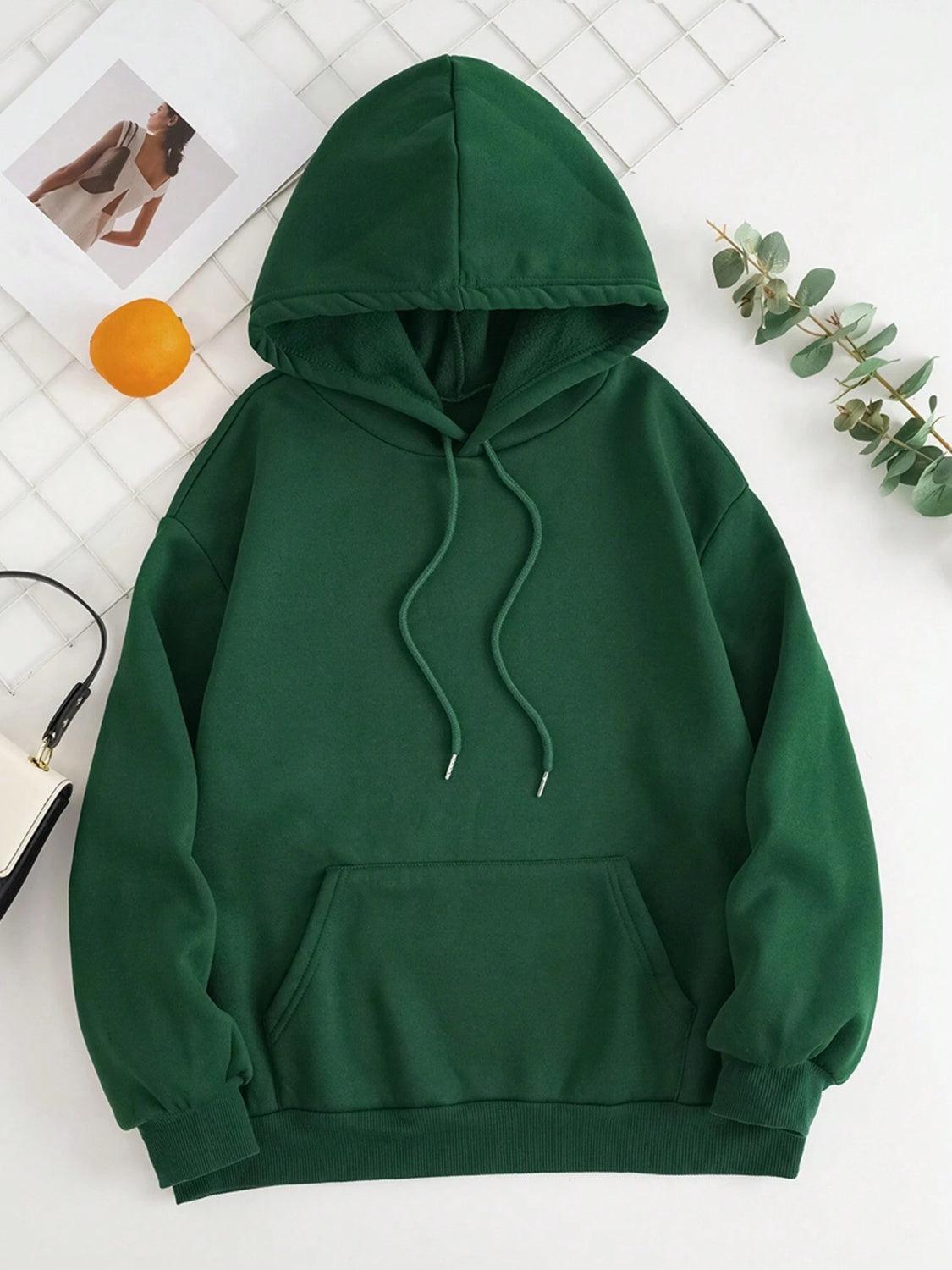 a green hoodie sitting on top of a white table