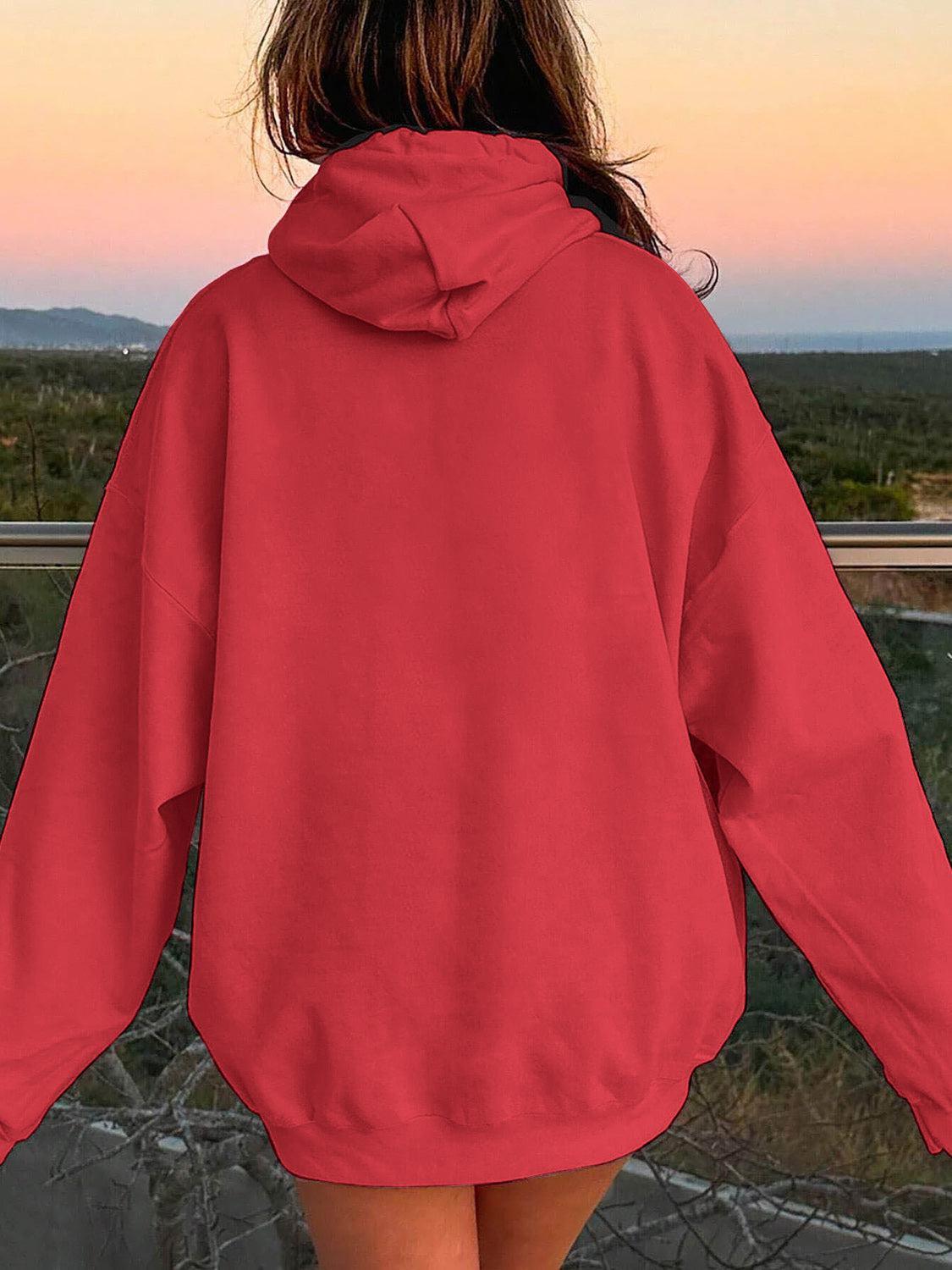 a woman in a red hoodie looking out at the desert