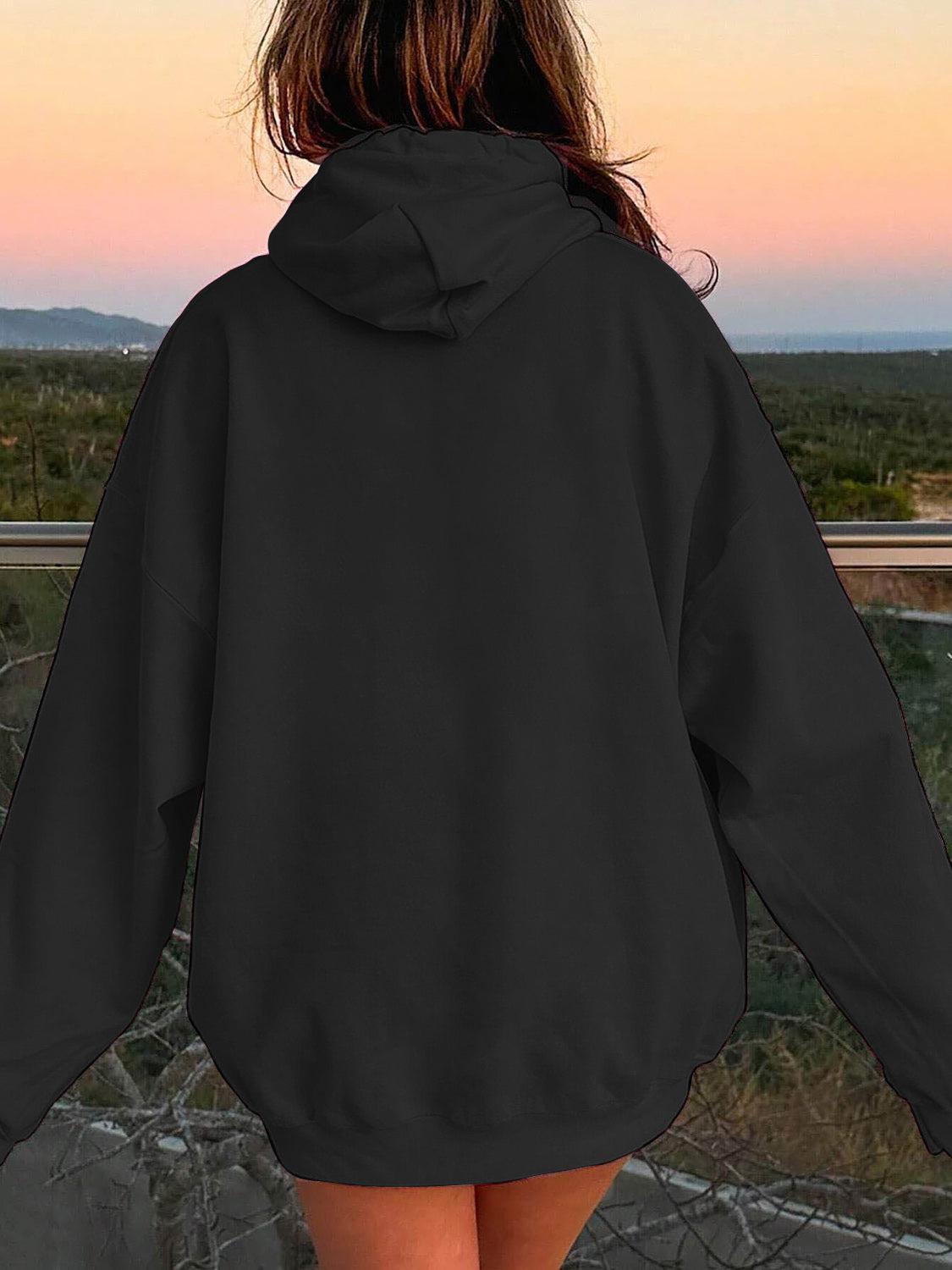 a woman in a black hoodie looking at the sunset