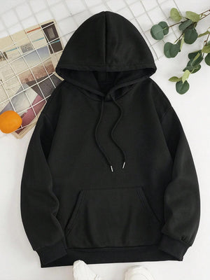 a black hoodie with a pair of white sneakers next to it