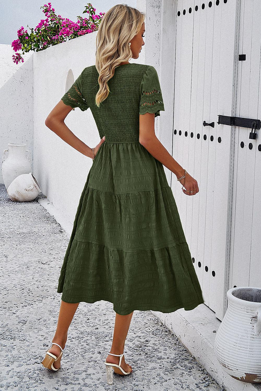 a woman in a green dress standing in front of a door