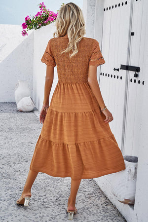 a woman in a brown dress is standing outside